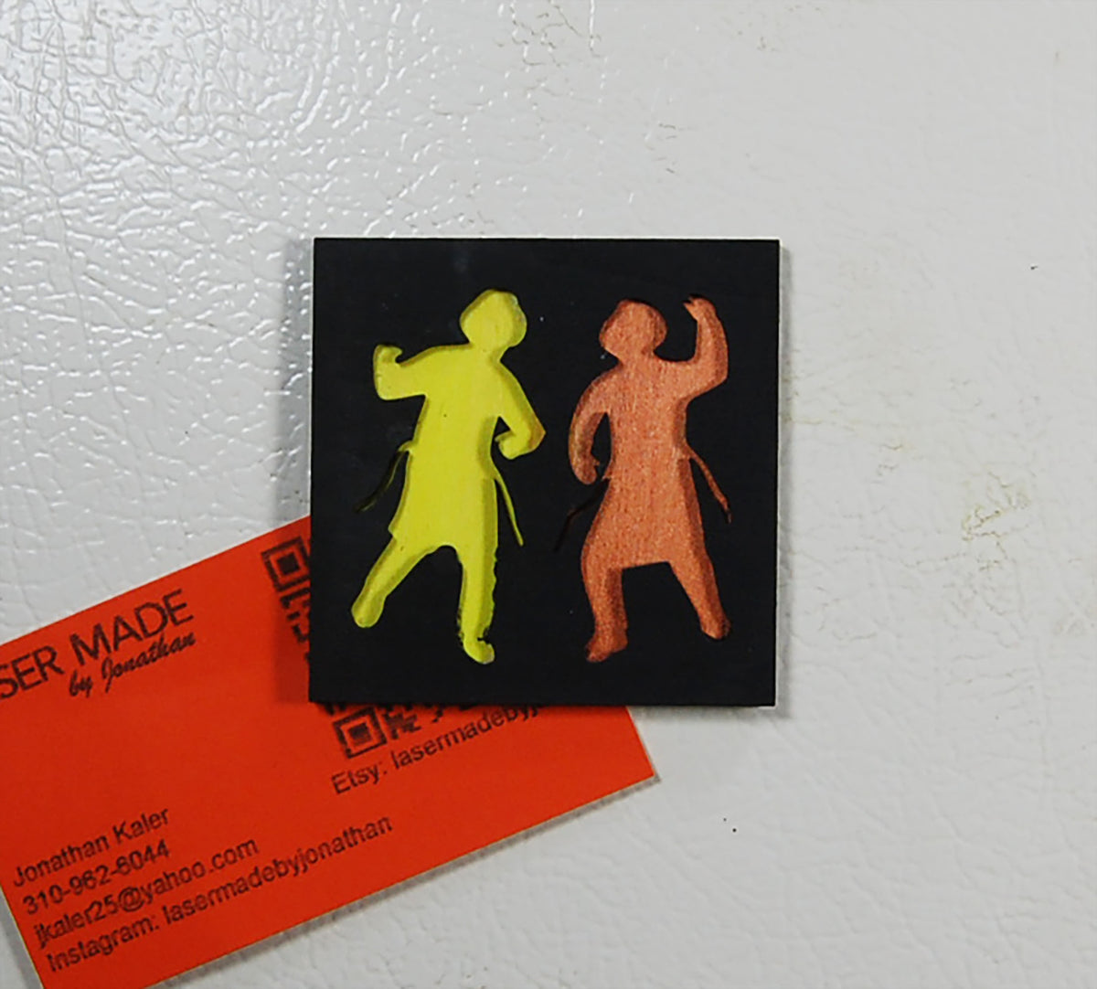Hand-painted basswood magnet showing two dancing figures