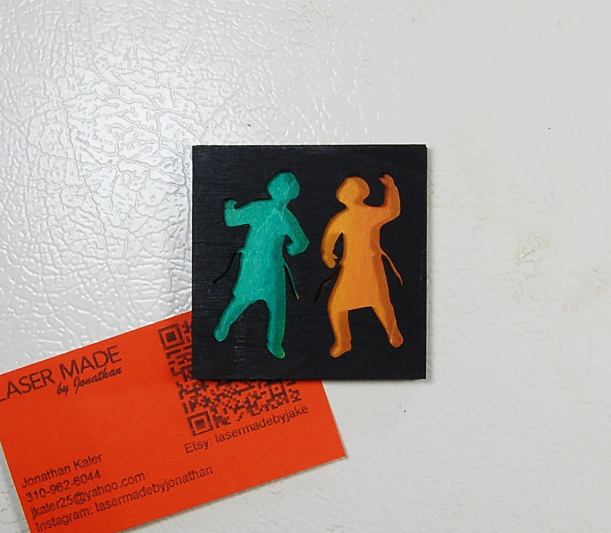 Hand-painted basswood magnet showing two dancing figures