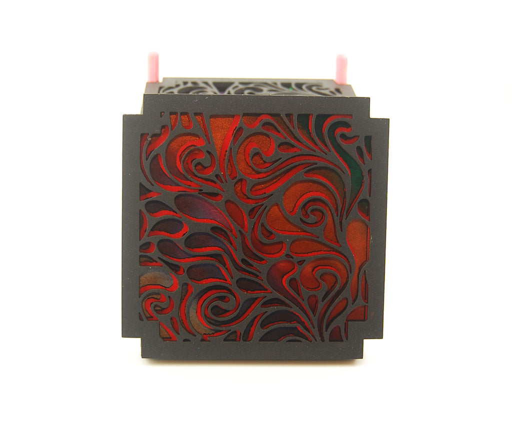 Stack of colorful square laser-cut scrollwork coasters in a purple holder