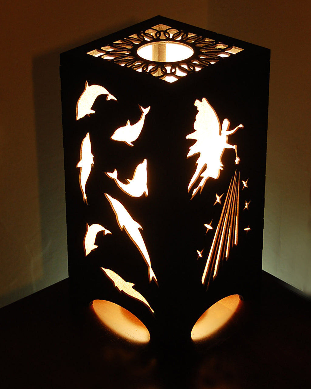 Fairies and dolphins lantern glowing with warm light, fairy and dolphin silhouettes illuminated