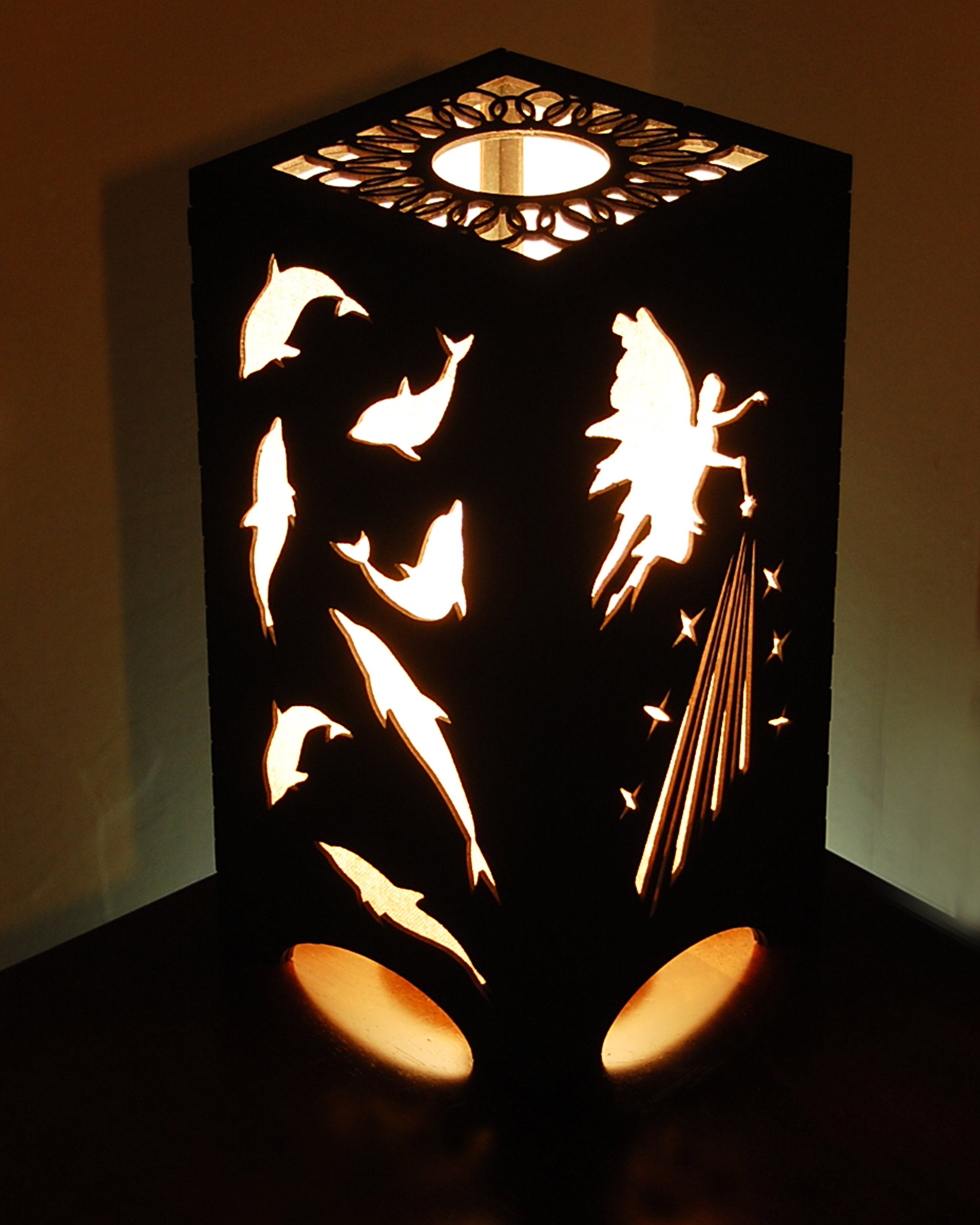 Fairies and dolphins lantern glowing with warm light, fairy and dolphin silhouettes illuminated