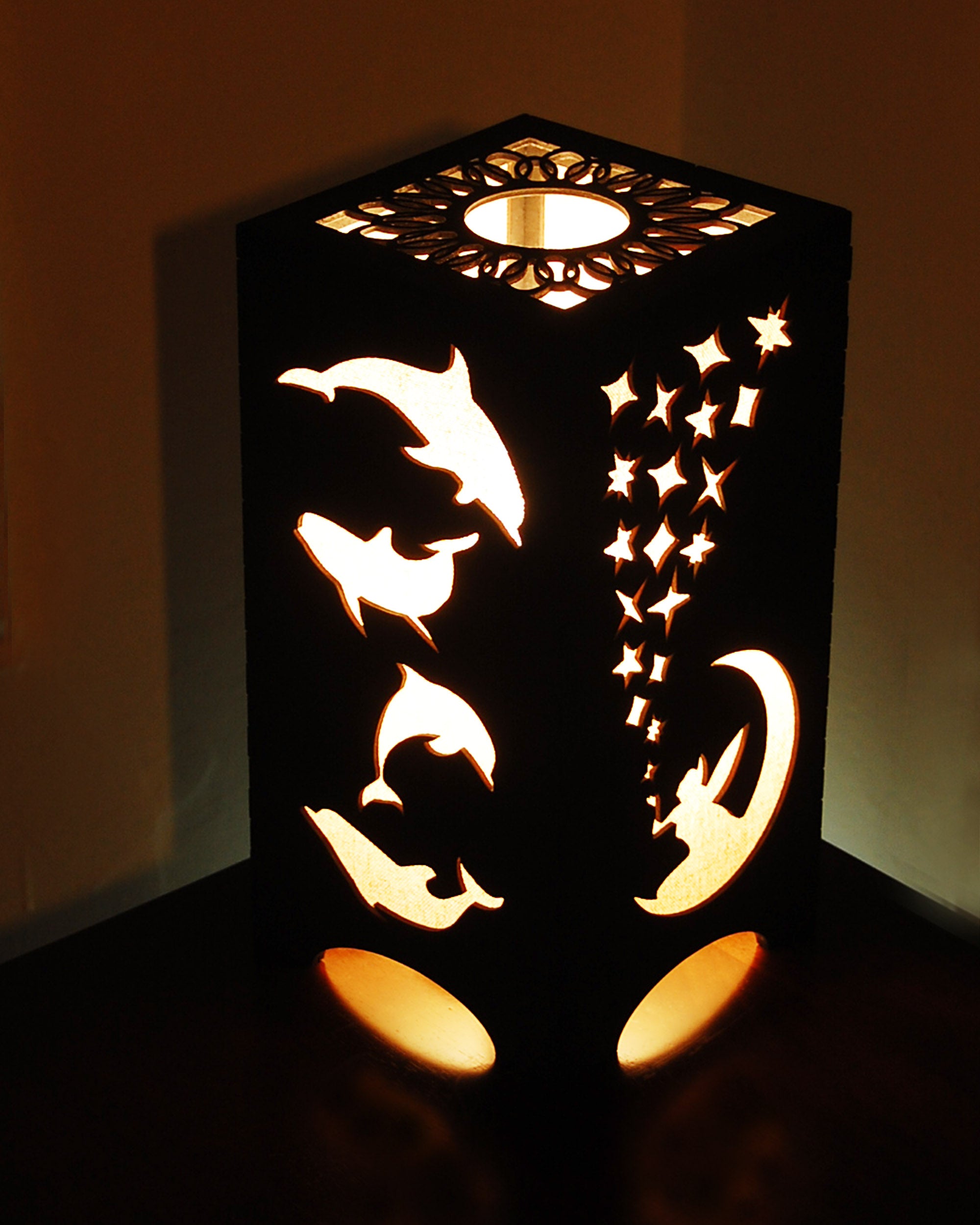 Fairies and dolphins lantern lit, showing moon, stars and dolphin cutouts glowing