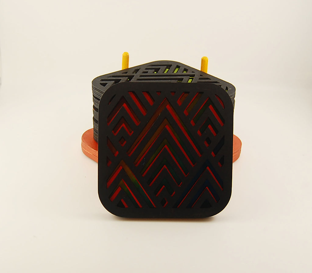 Square laser-cut angular coaster set stacked in a colorful storage holder