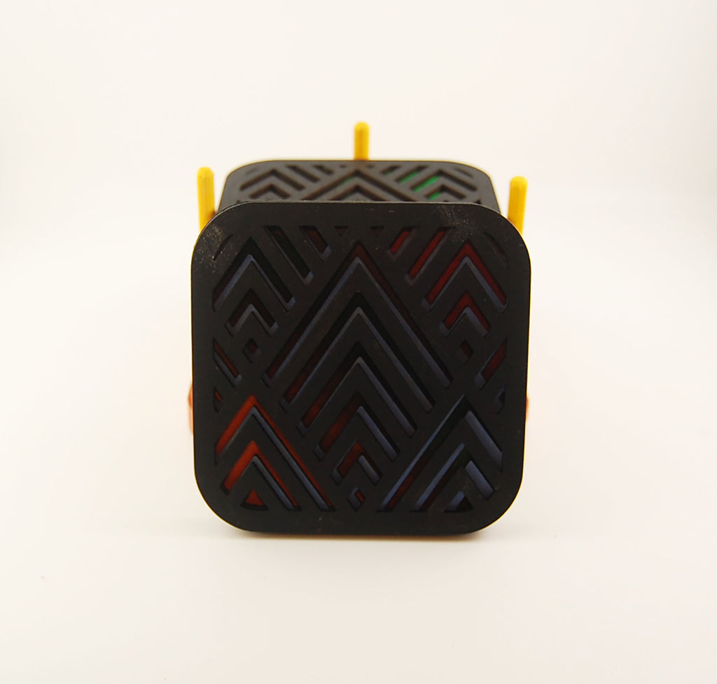 Close-up of square laser-cut coaster with colorful layered angular pattern
