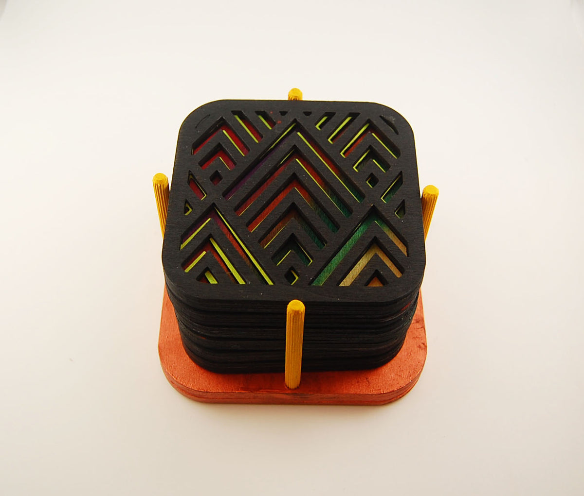 Six square laser-cut angular coasters arranged in their storage holder