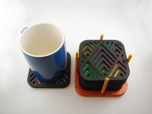 Square laser-cut angular coaster set shown beside a blue mug