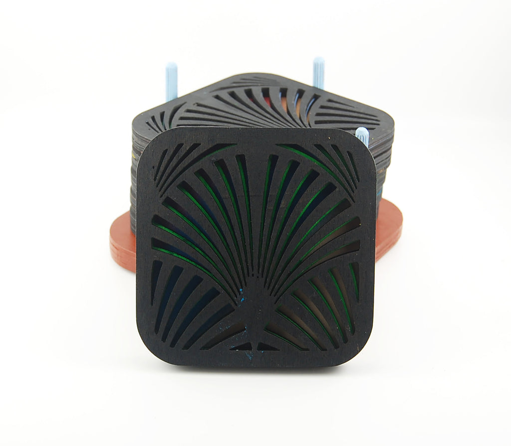 Close-up of a square laser-cut coaster with a dark fan pattern