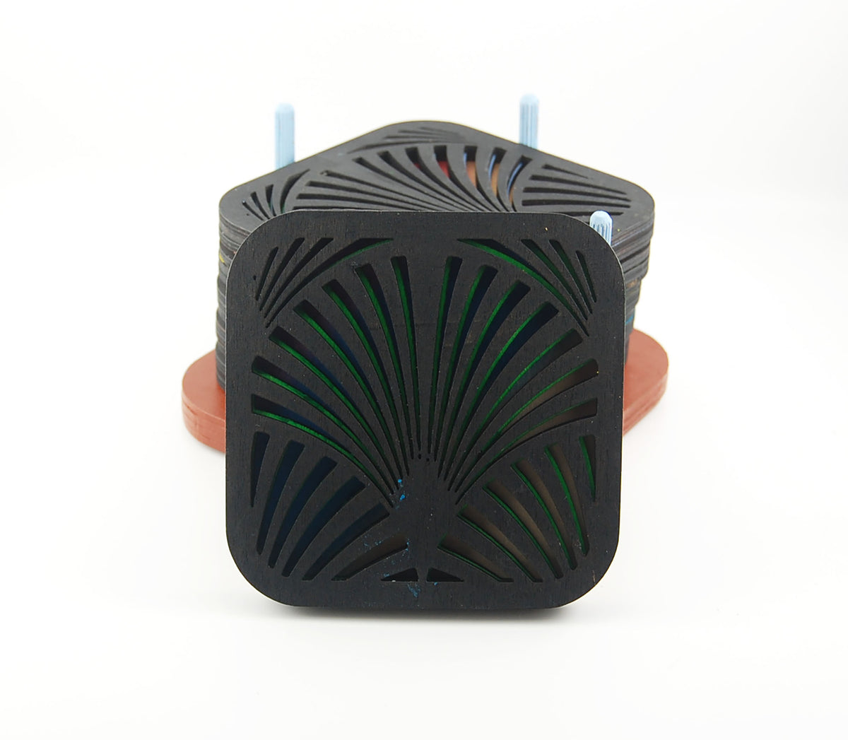 Close-up of a square laser-cut coaster with a dark fan pattern