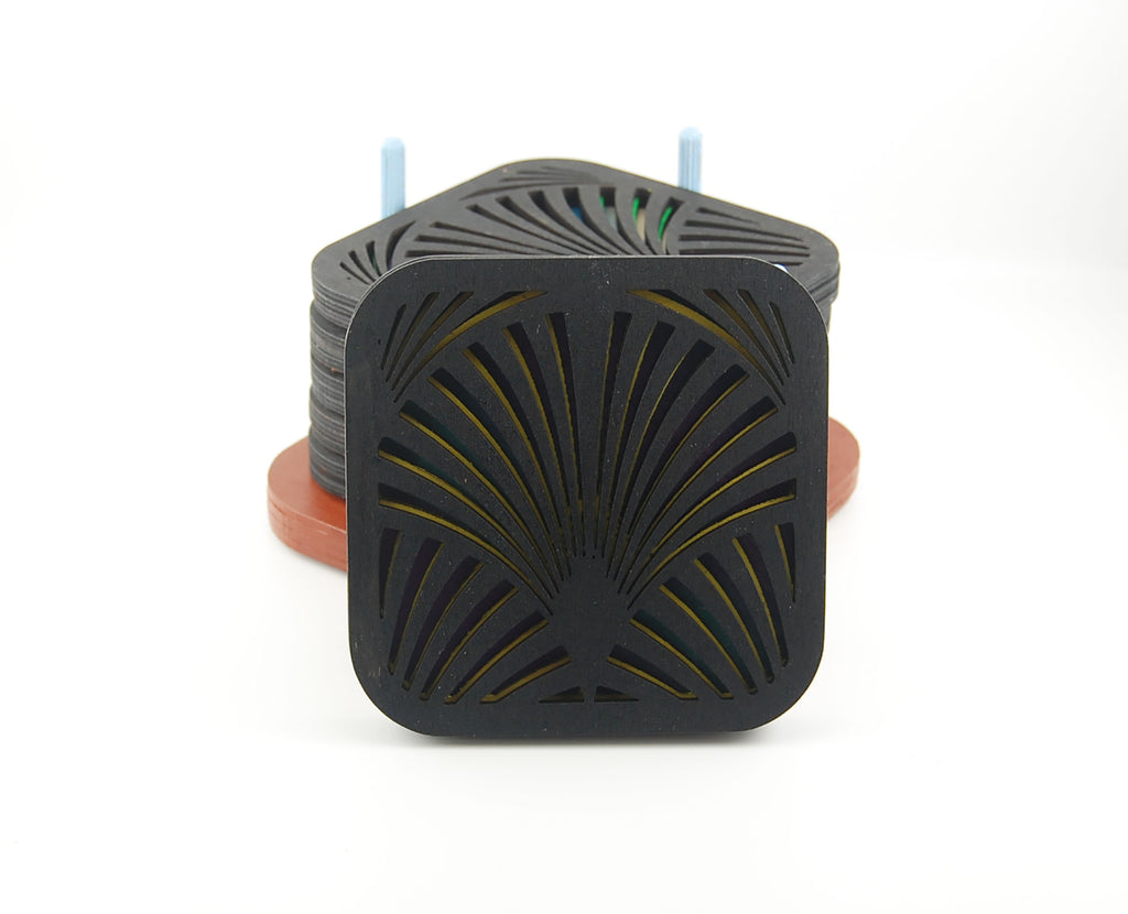 Square coaster showing colorful layered design beneath a dark geometric pattern