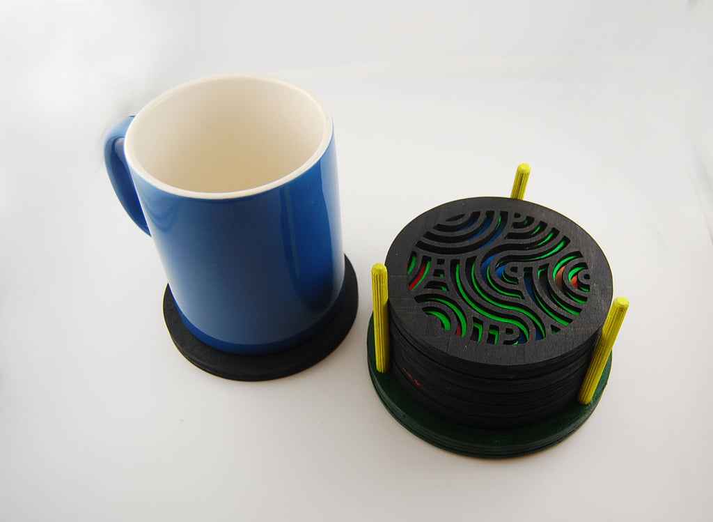 Round laser-cut coaster set shown beside a blue mug