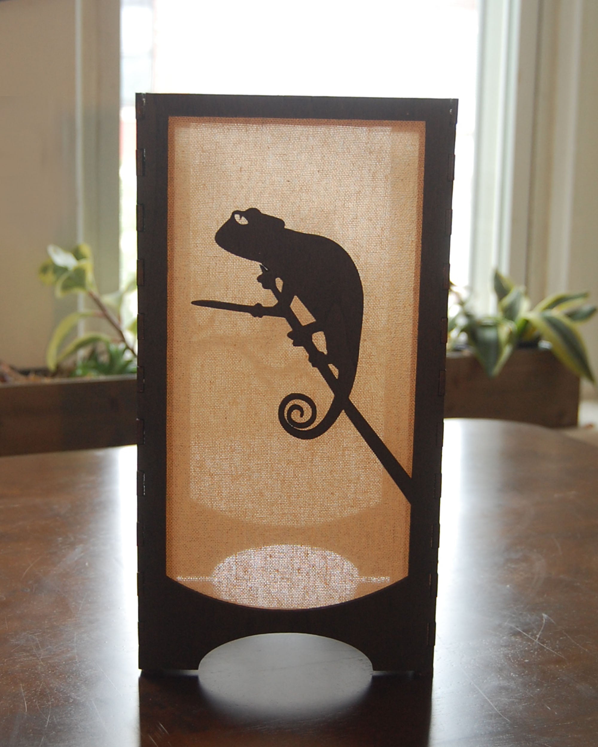 Handmade laser-cut wildlife lantern — chameleon silhouette in natural  light